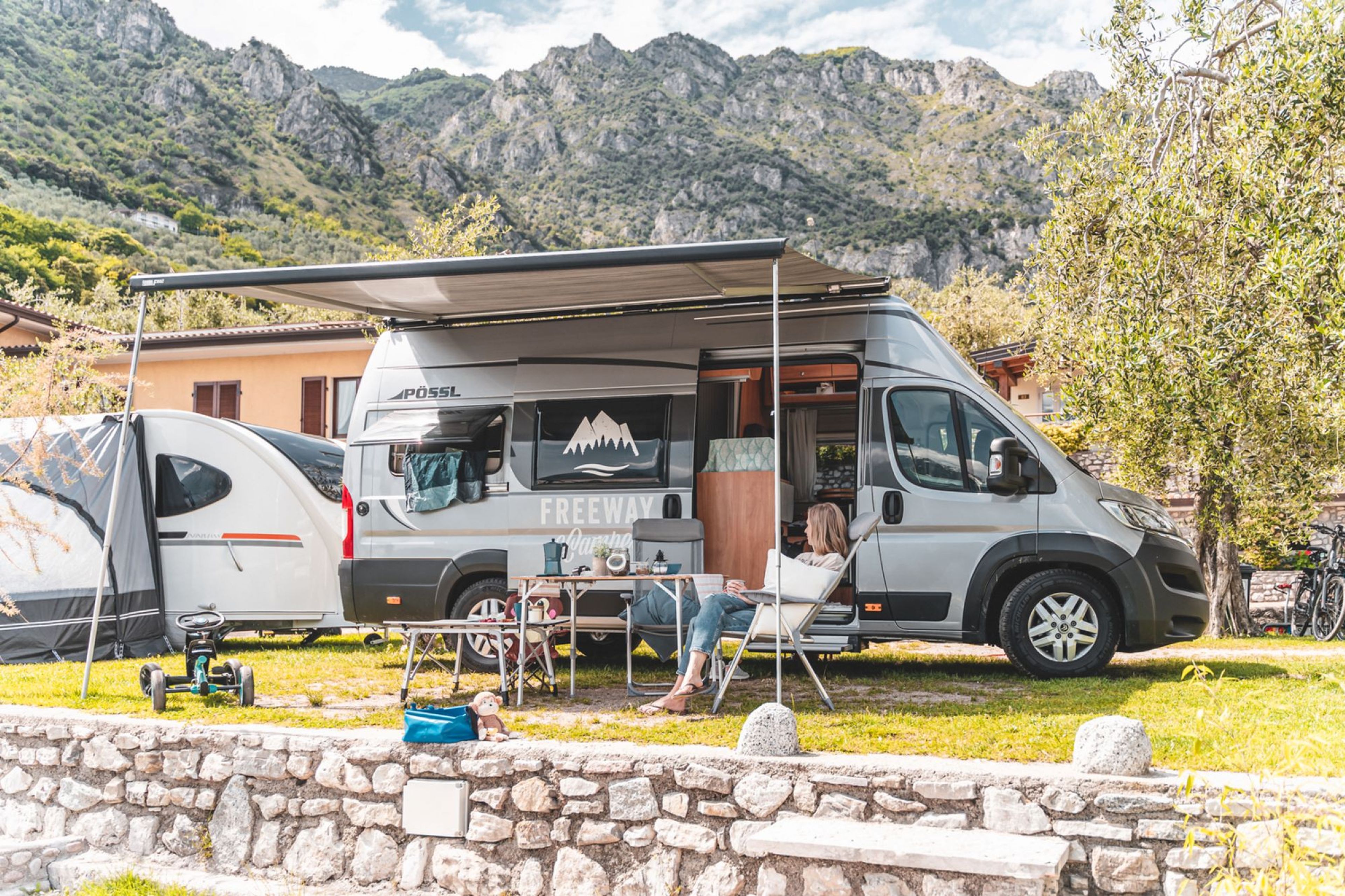 Eine Familie mit Kindern hat Spaß in einem Wohnmobil auf dem Weg zum Gardasee