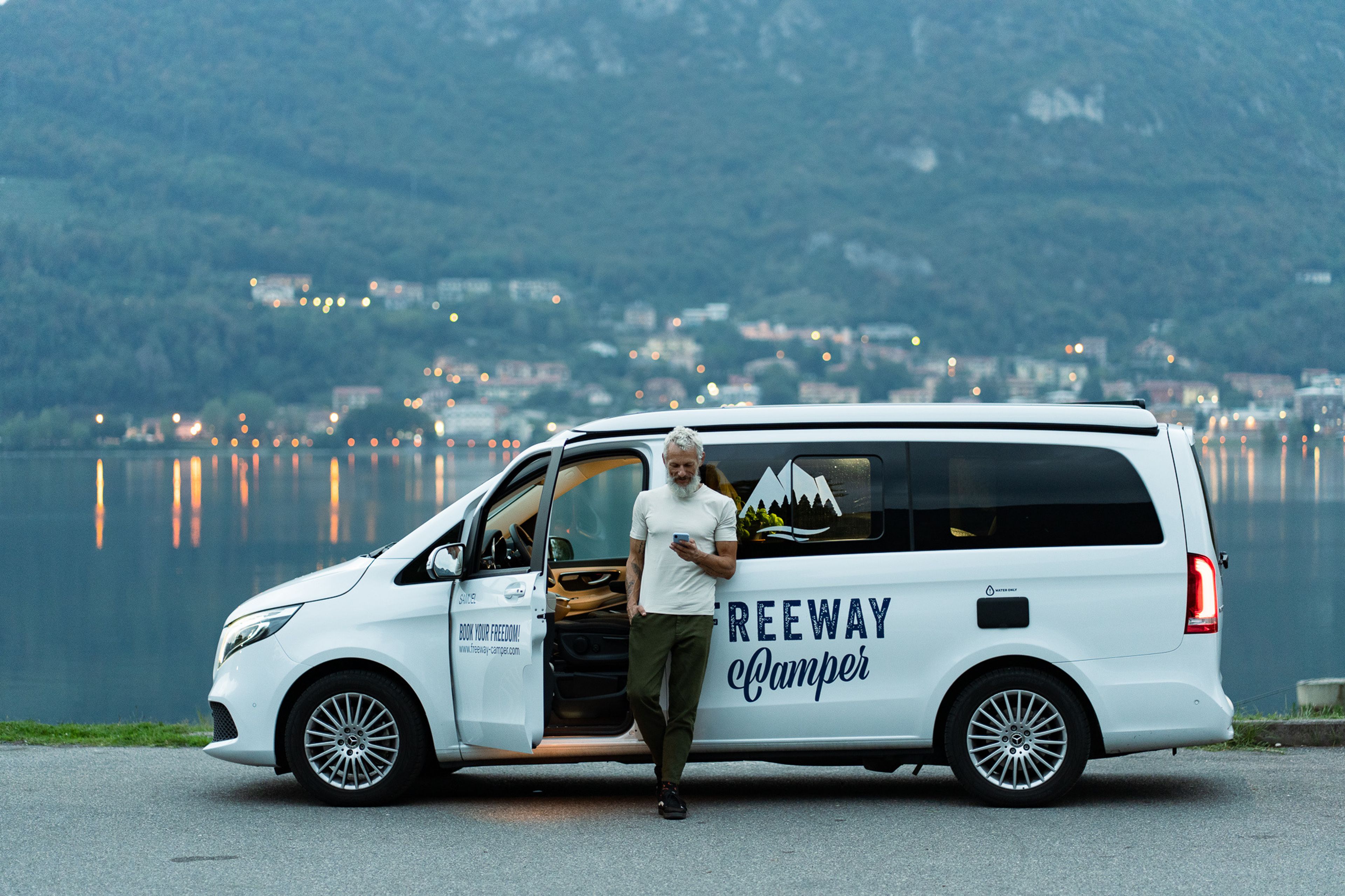 Man with mobile phone in hand in front of Mercedes Marco Polo camper van