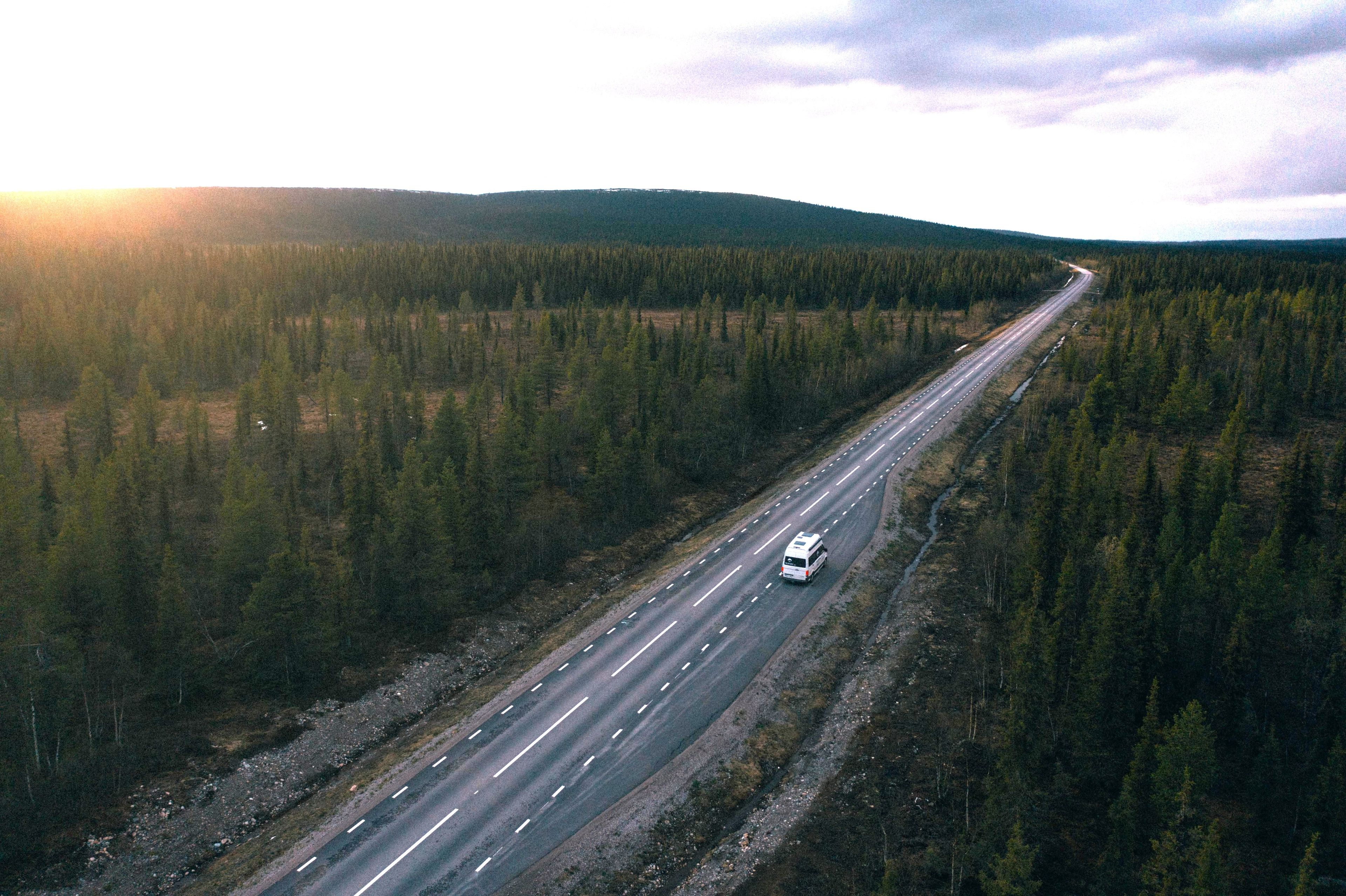 VW Grand California auf langer Waldstraße in Norwegen