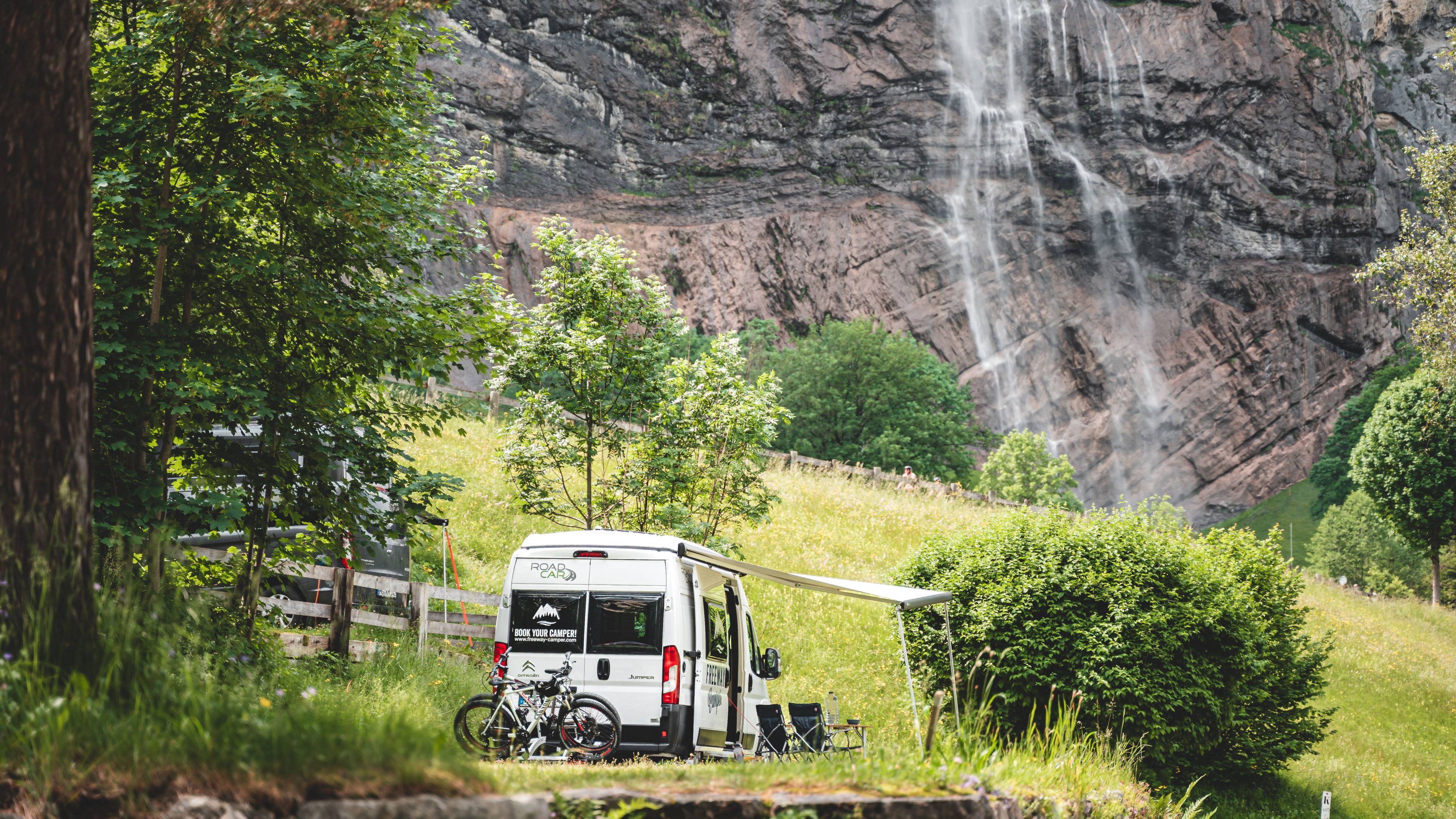 Camper in front of a waterfall