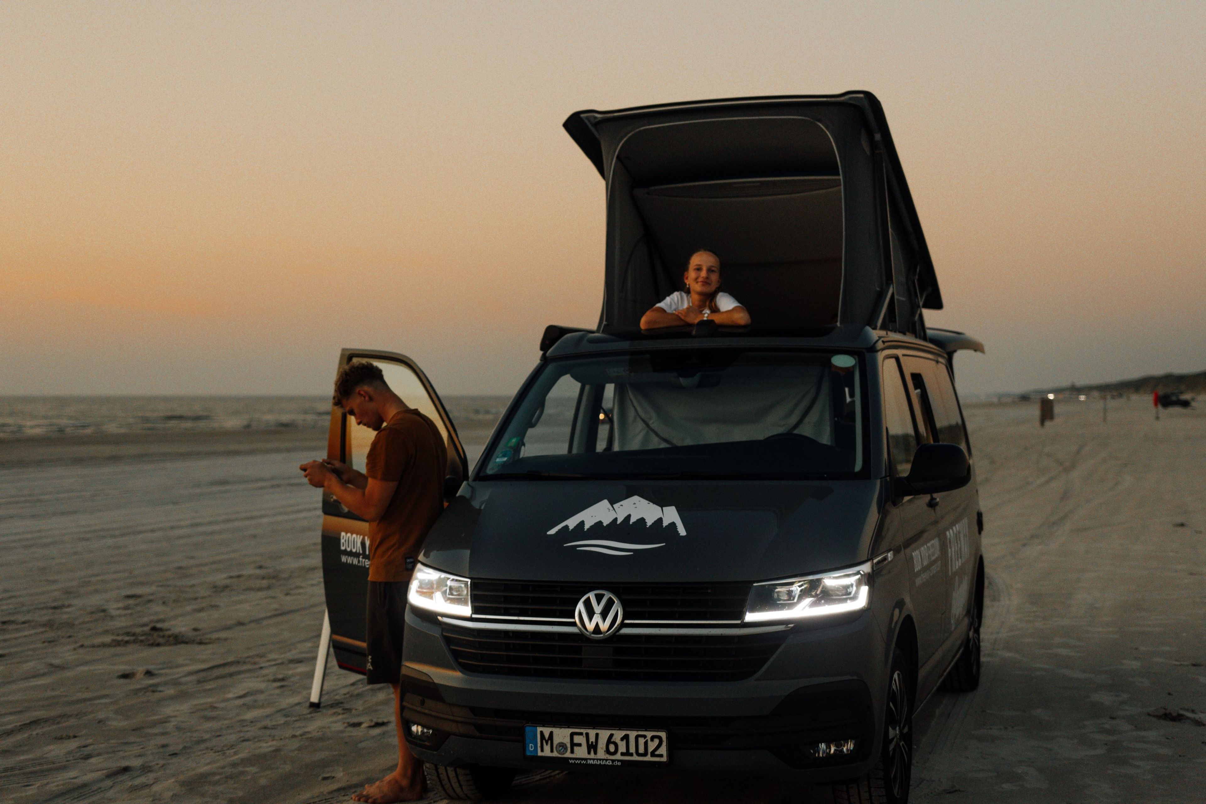 Sonnenuntergang am Strand im VW Bulli mit Aufstelldach