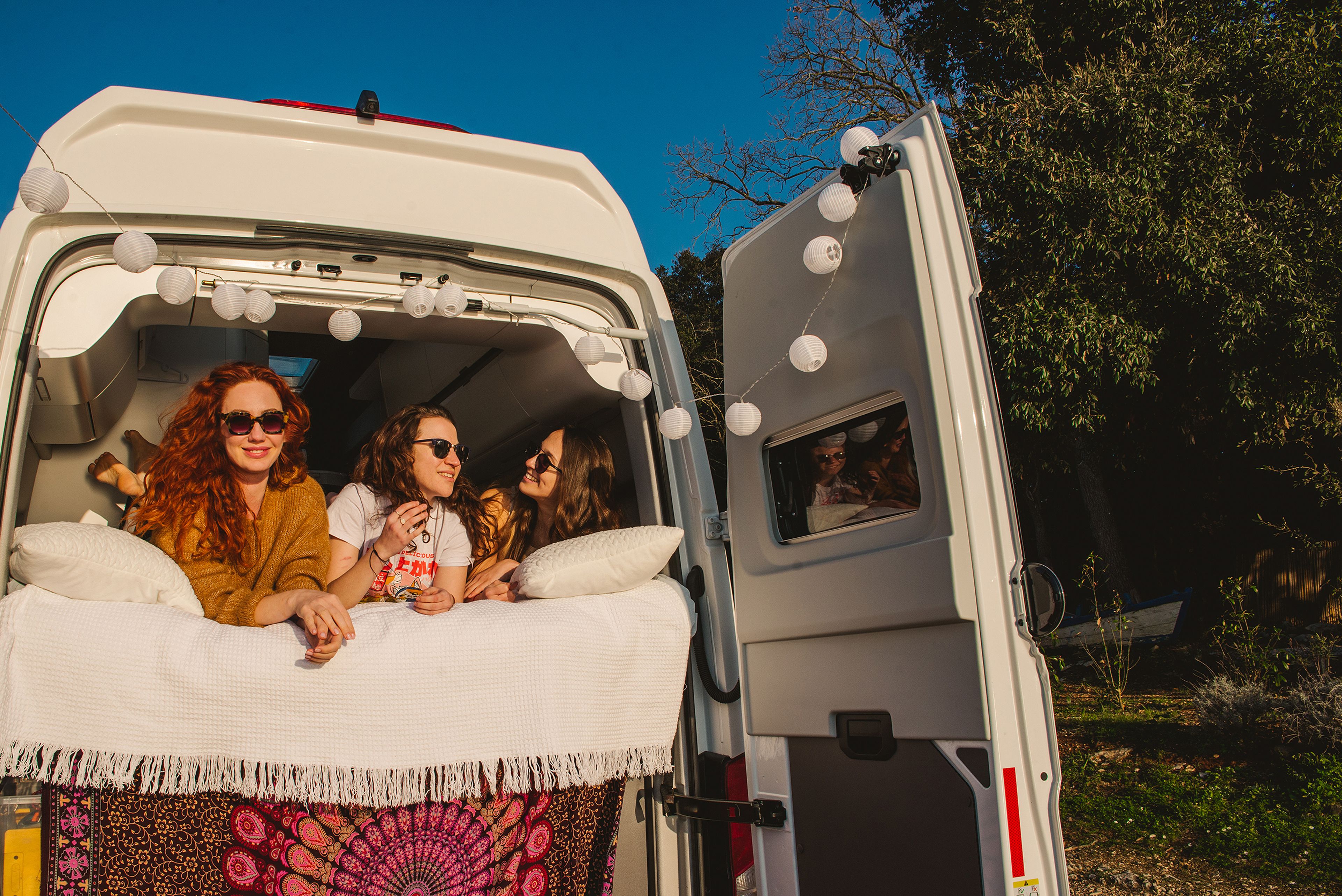 Drei Frauen im gemütlichen Bett des VW Grand California in Pula, Istrien