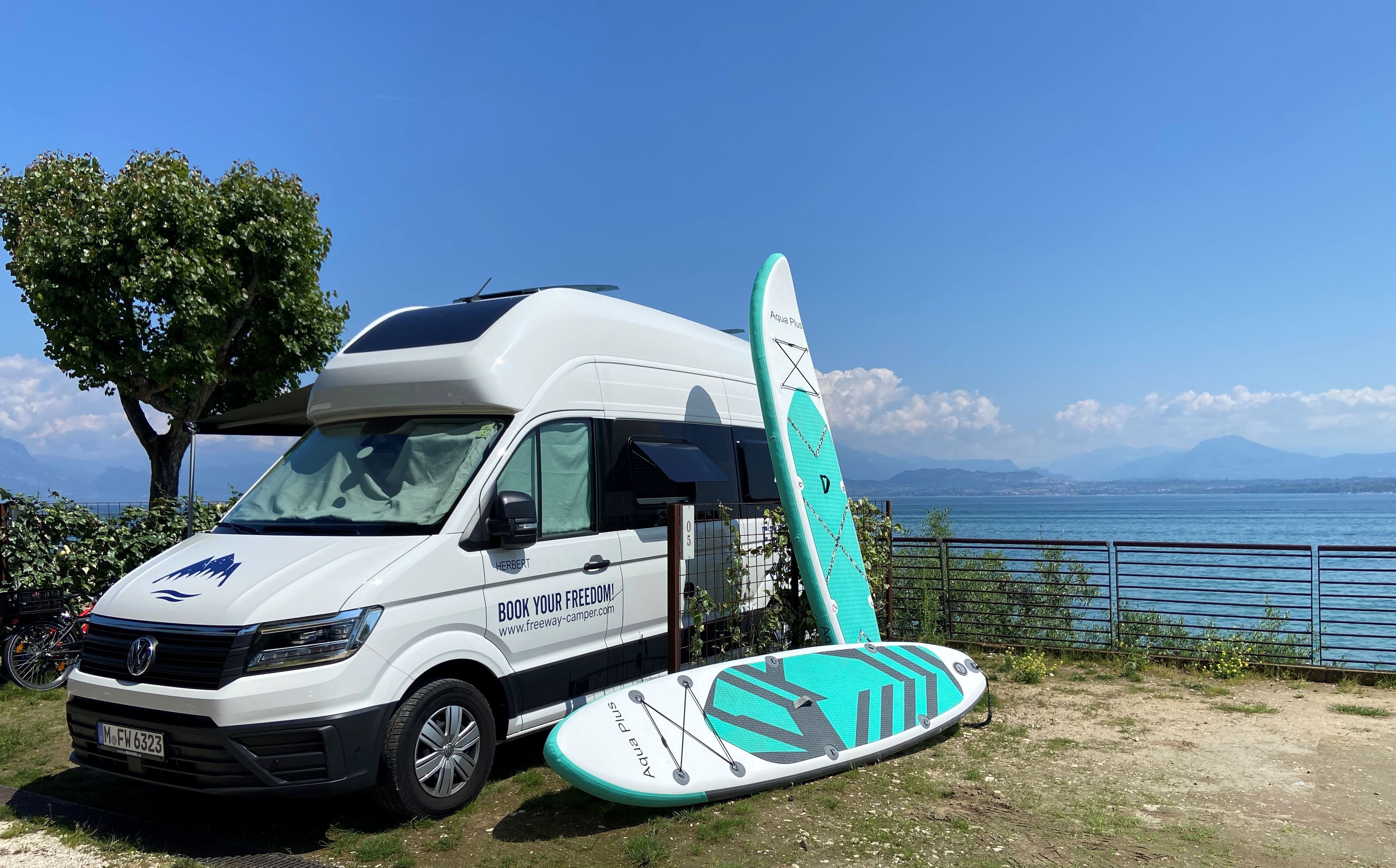 VW Grand California und SUP-Boards auf Stellplatz