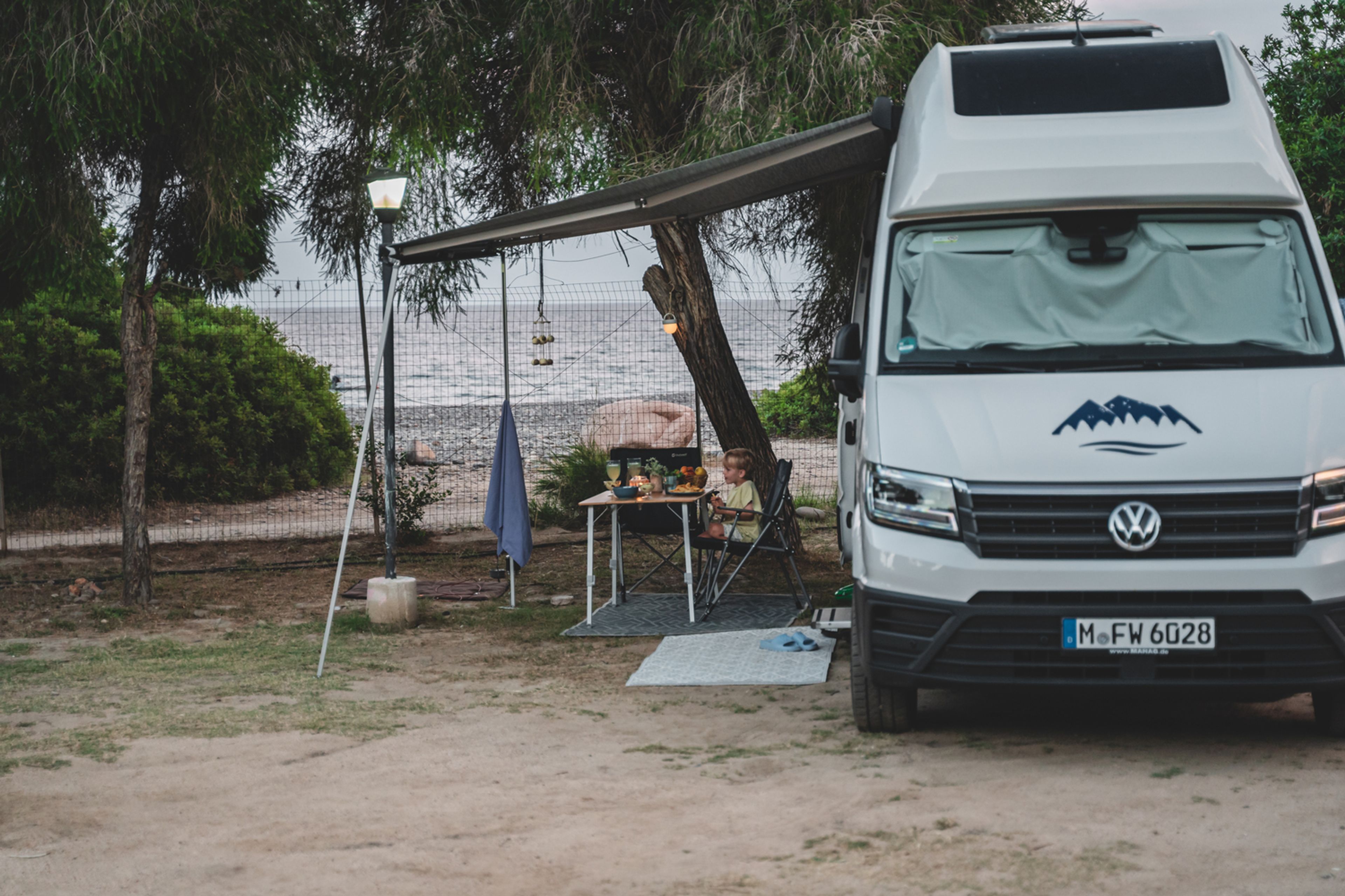 Camper Furgonato VW in un campeggio sul mare in Liguria in una tarda serata estiva