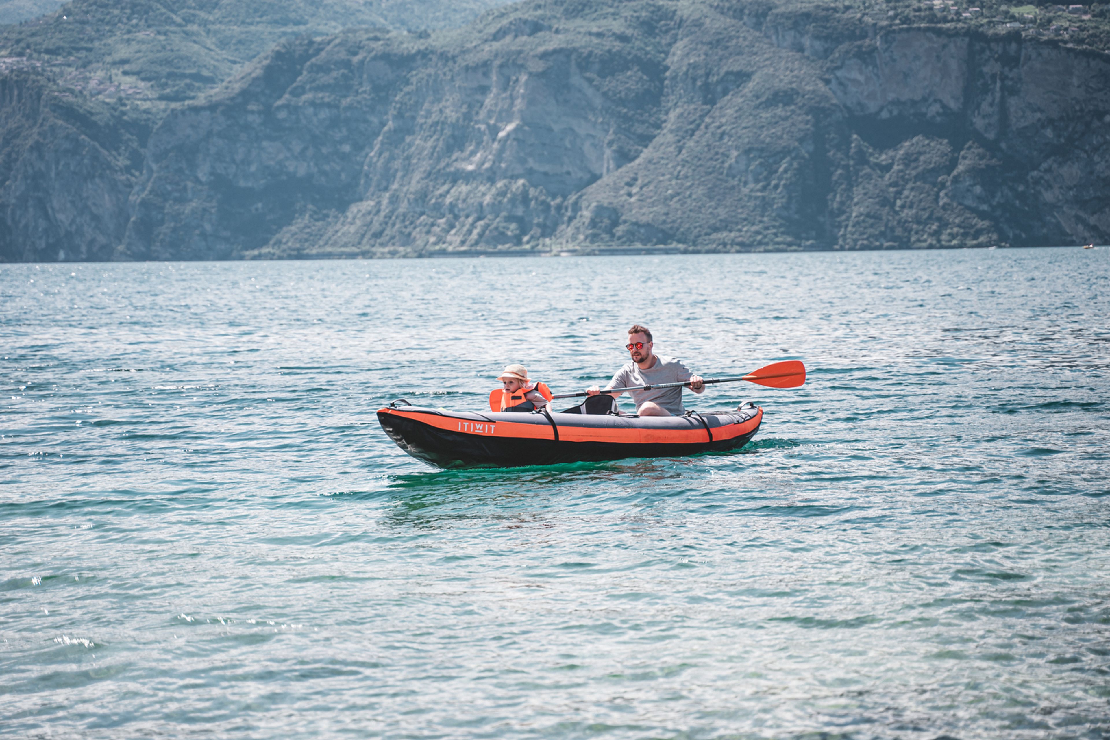 Padre e figlio si divertono in kayak sul lago di Garda durante il loro viaggio in campeggio
