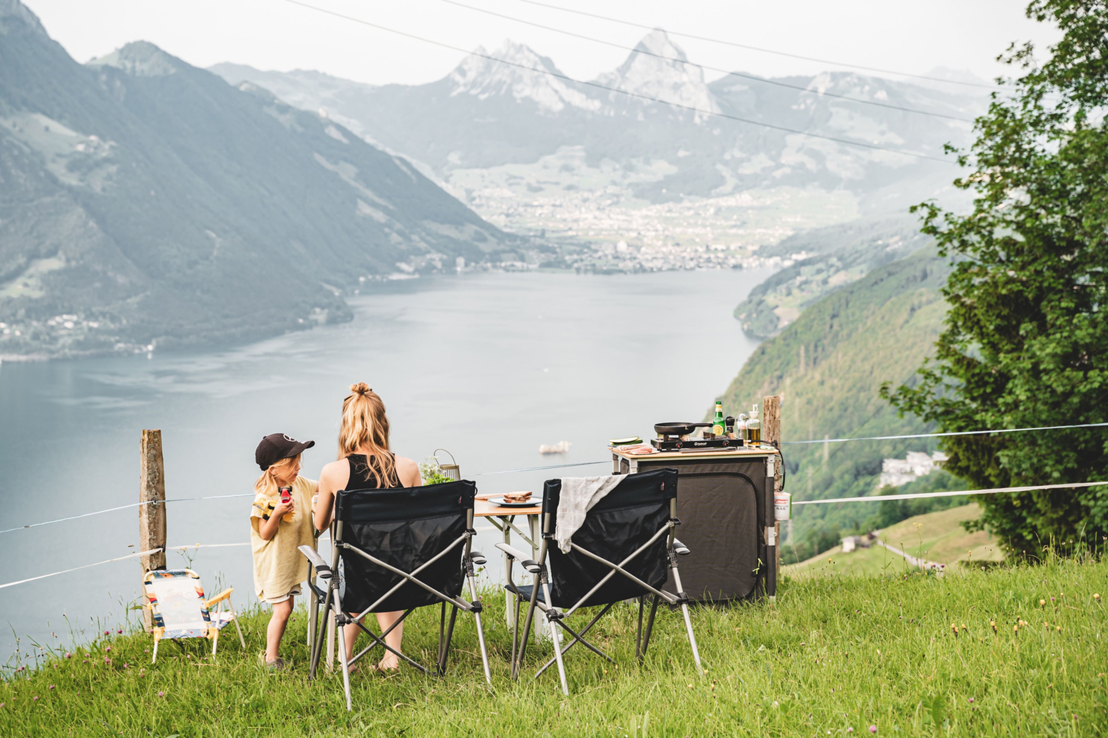 Mamma e bambino hanno preparato il pranzo all’aperto. Sullo sfondo le montagne e la valle attraversata dal lago in Svizzera