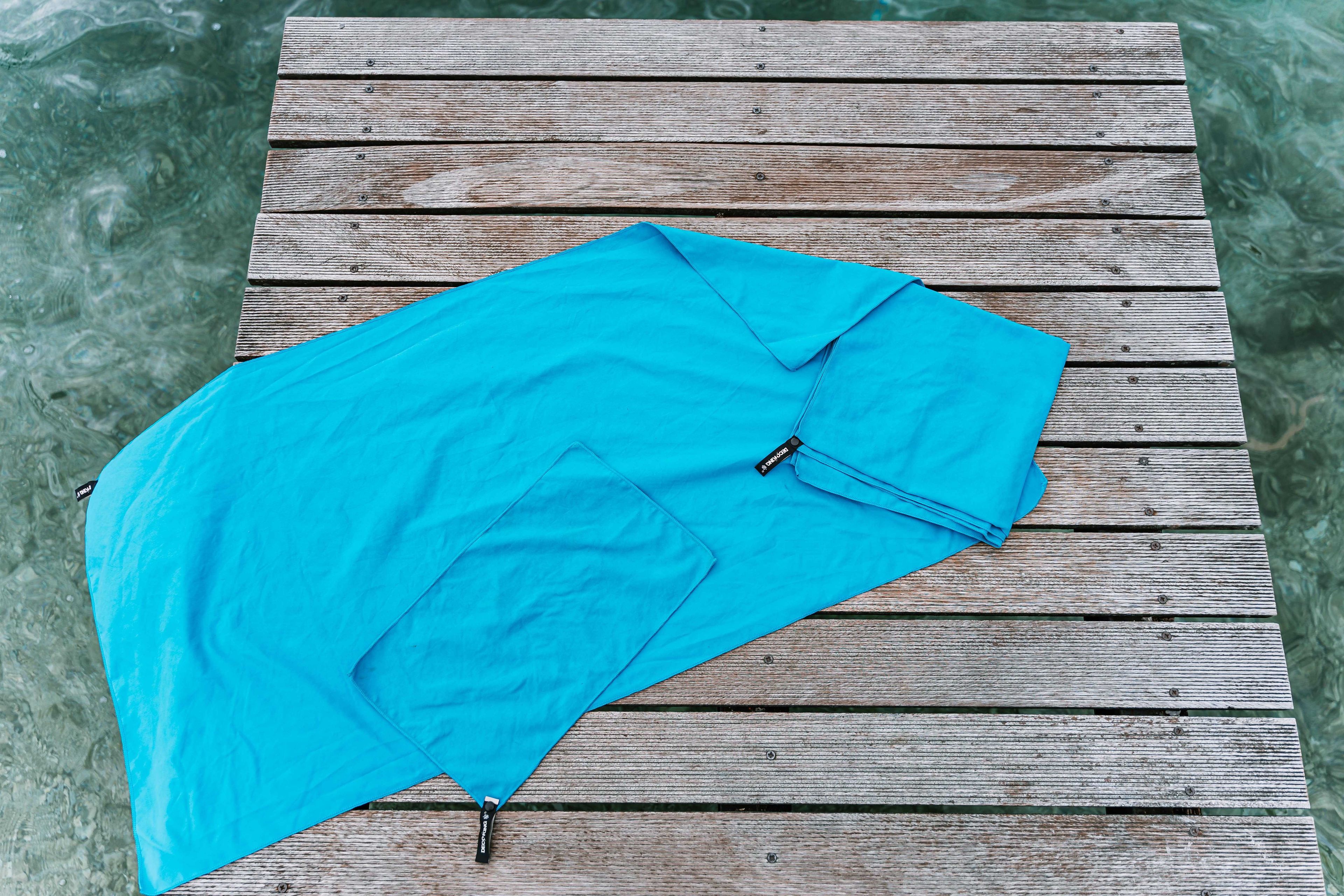 Blue microfiber towels on dock by the lake.