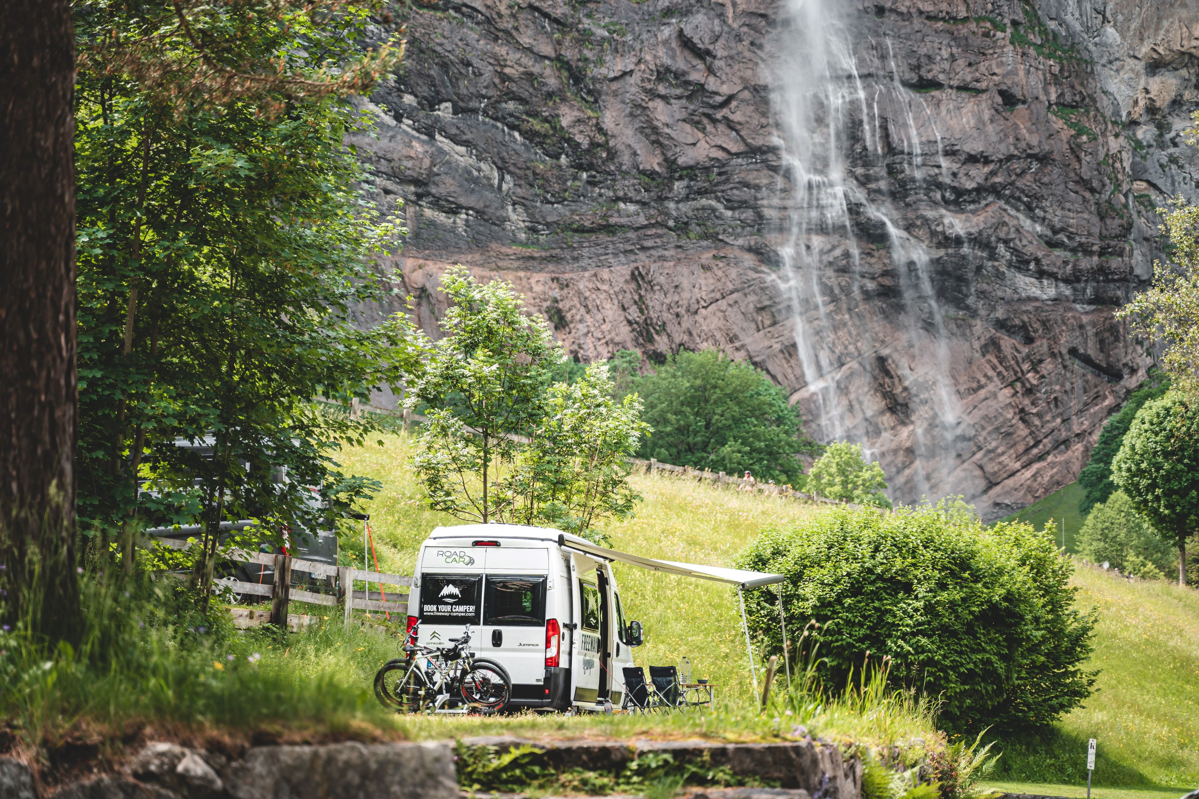 Camper in front of a waterfall