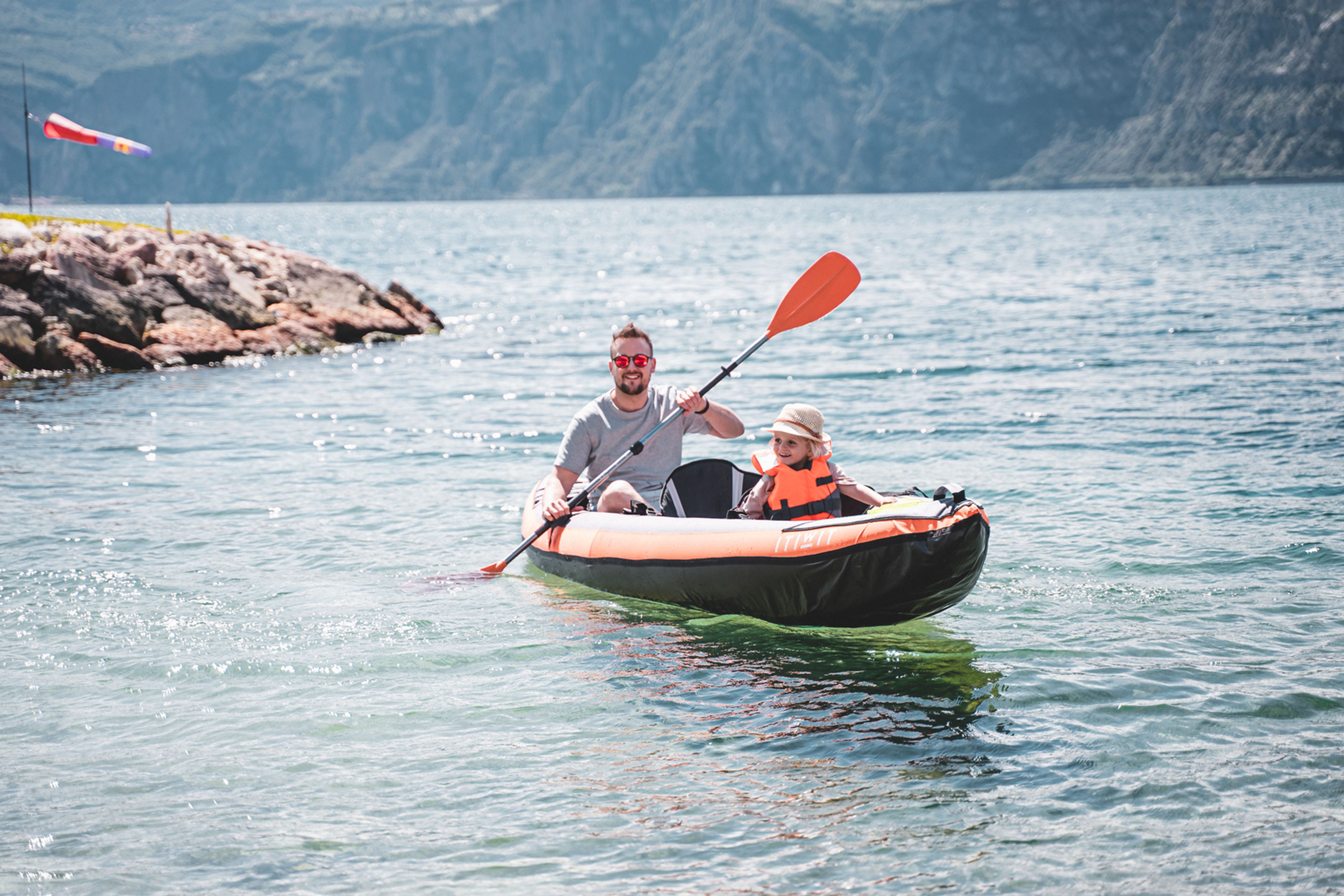 un papà e un figlio in kayak durante il loro campeggio sul lago di Garda